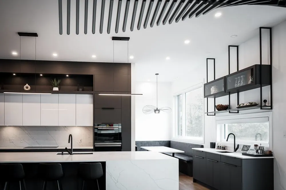 Modern kitchen with a black slatted ceiling and a recessed banquette