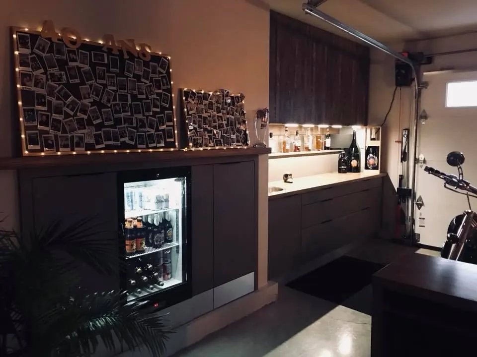 Finished garage with a lit bar and a glass door fridge